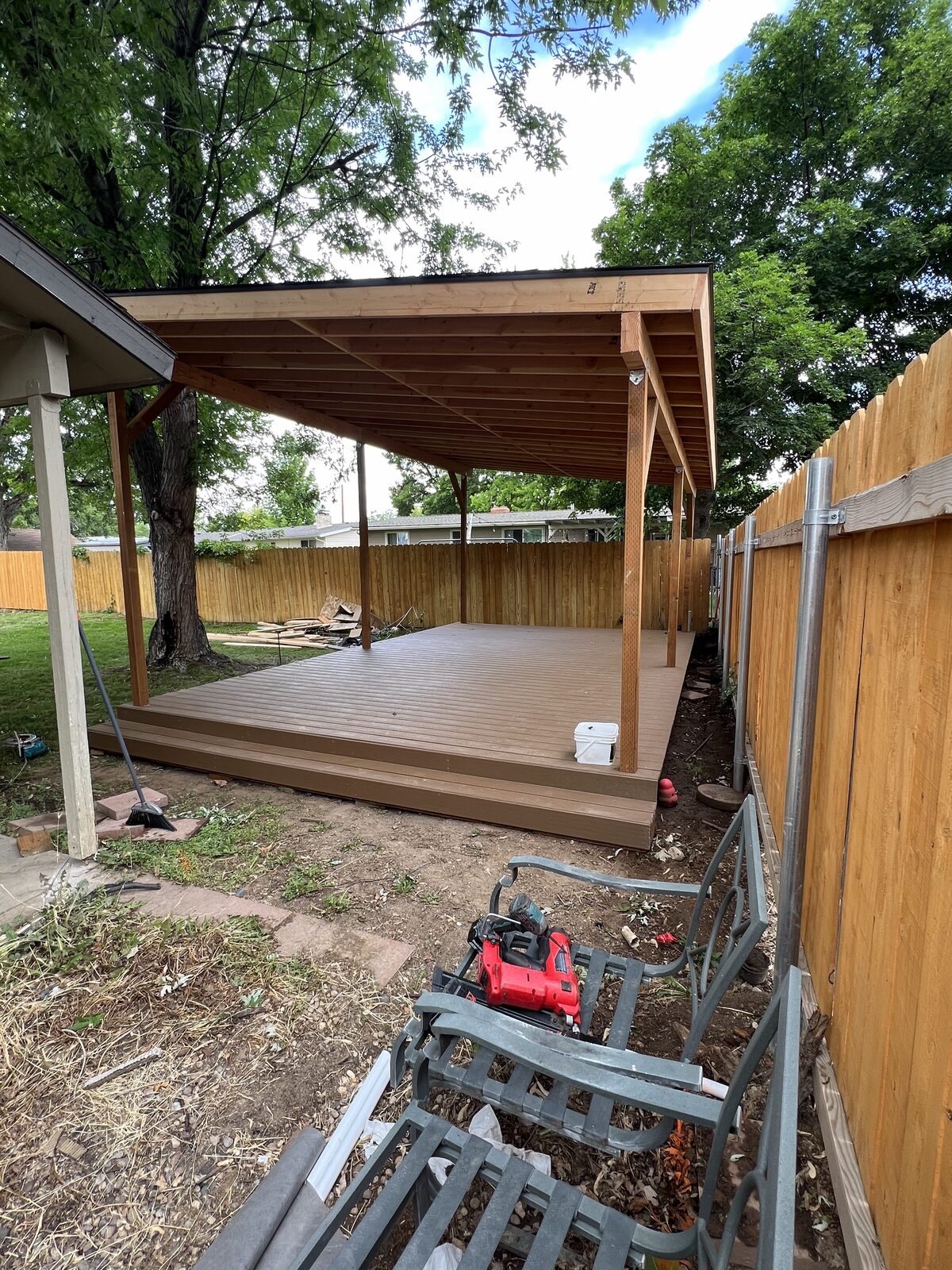 Finished solid-roof wood patio cover over a backyard deck