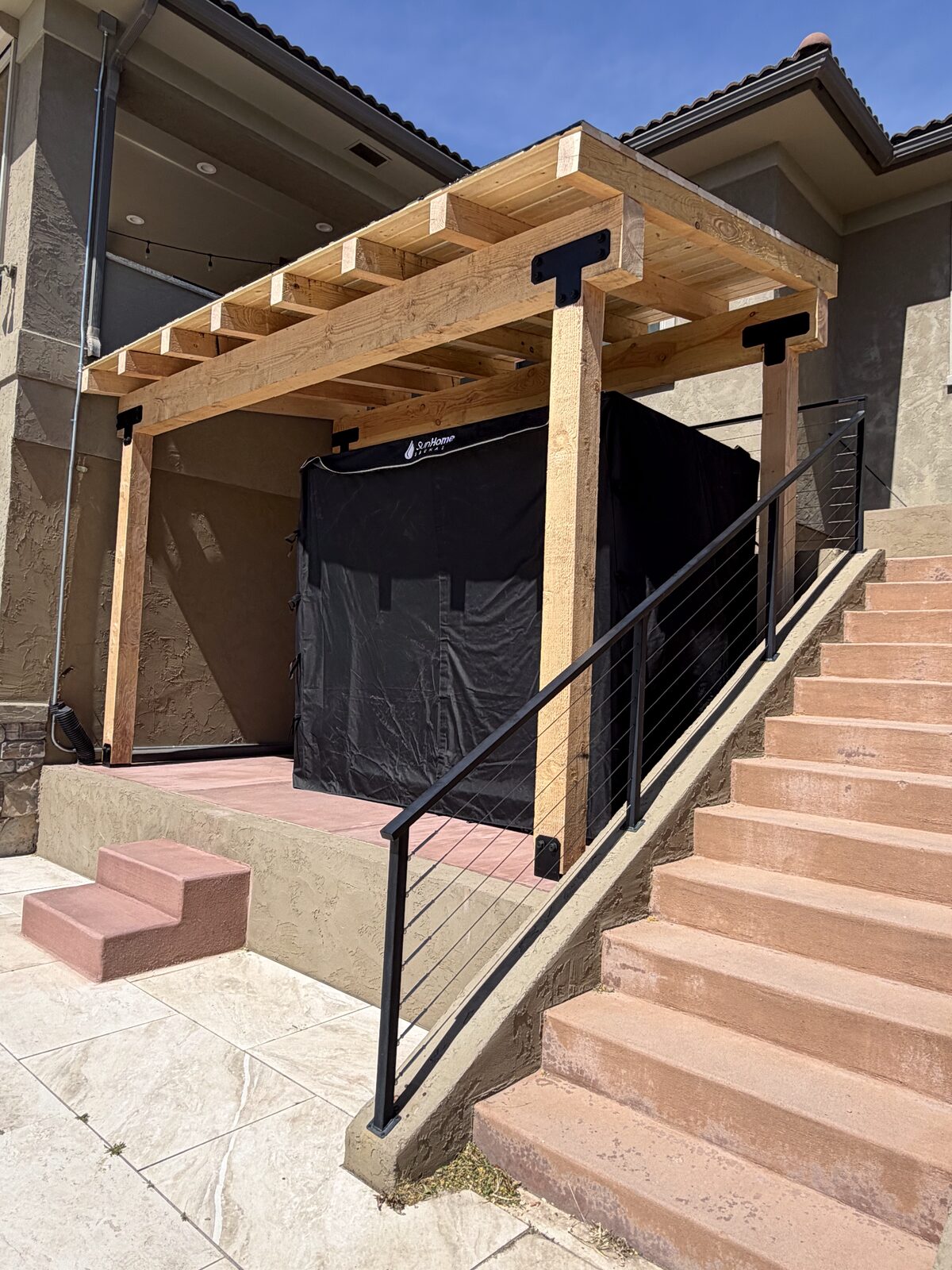 Cedar pergola built over a backyard hot tub with cable railing